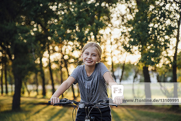 Portrait of girl riding bicycle at park