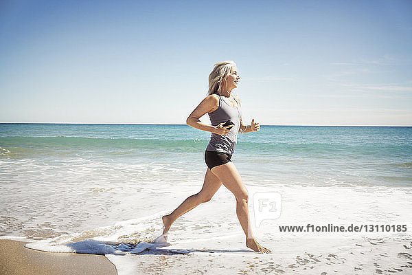 Volle Länge einer reifen Frau  die am Delray-Strand am Meeresufer joggt