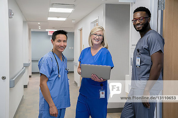 Portrait of confident doctors standing in hospital corridor