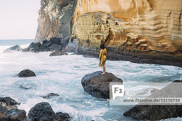 Rückansicht einer auf einem Felsen stehenden Frau auf der Insel Réunion