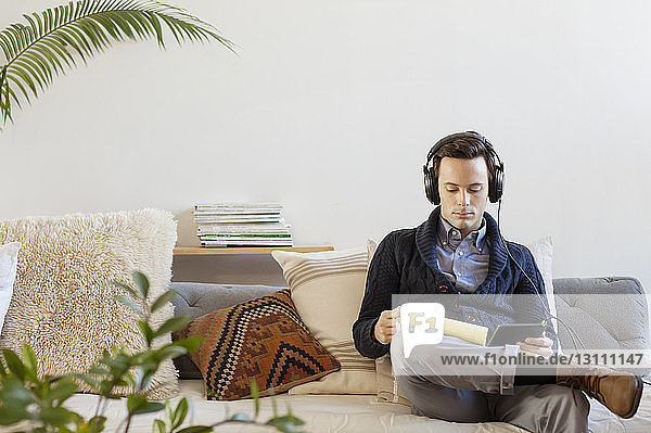 Geschäftsmann  der während seiner Arbeit im Büro Musik hört