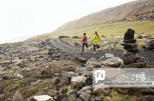 Female friends jogging on mountain path