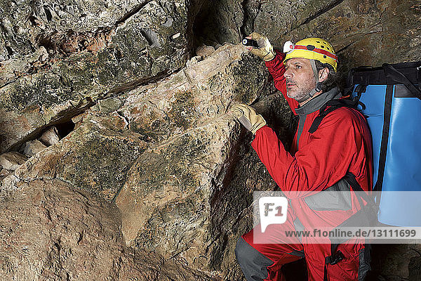 Archäologe mit Rucksack in Höhle stehend