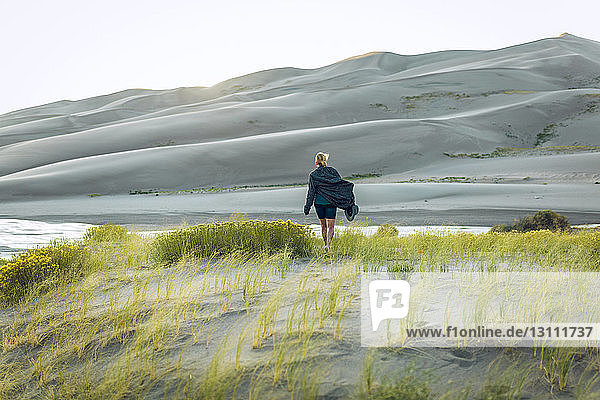 Rear view of woman amidst plants at Great Sand Dunes National Park