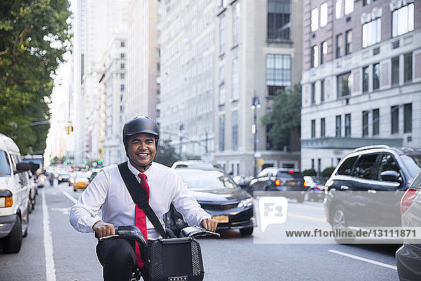 Businessman riding bicycle on city street