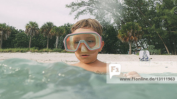 Boy looking away while swimming in sea