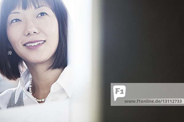 Close-up of smiling businesswoman sitting at office