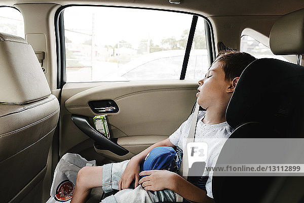 Junge schläft im Auto