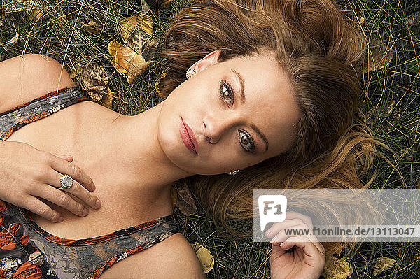 Portrait einer jungen Frau im Gras liegend