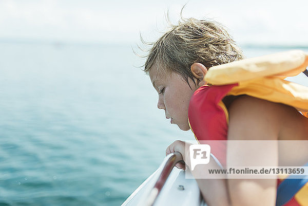 Seitenansicht eines Mädchens mit Schwimmweste  das im Boot auf dem See sitzt
