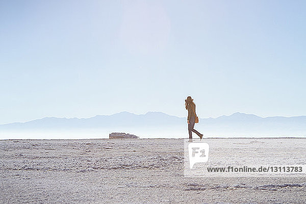 Seitenansicht einer Frau  die auf dem Feld gegen den klaren Himmel auf Antelope Island läuft