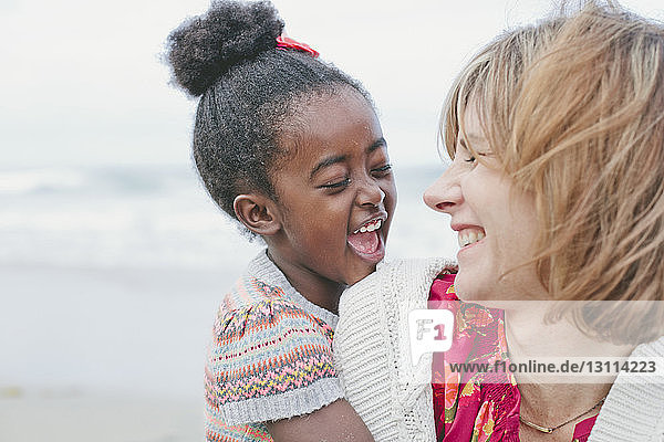 Cheerful mother and daughter at beach