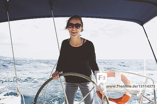 Lächelnde Frau fährt Boot auf See