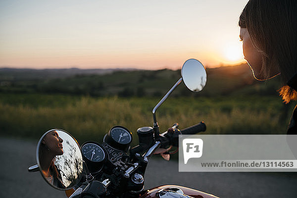 Nachdenkliche Motorradfahrerin schaut weg  während sie auf dem Motorrad sitzt