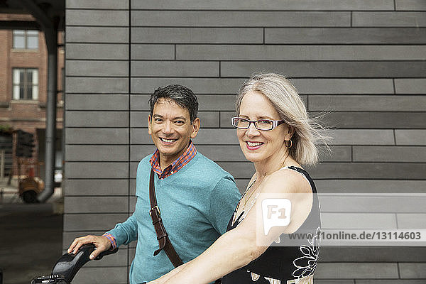 Porträt eines glücklichen reifen Paares an der Wand stehend