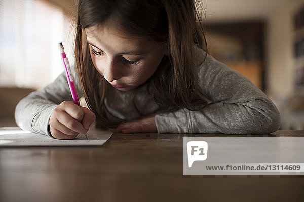 Mädchen schreibt Hausaufgaben zu Hause