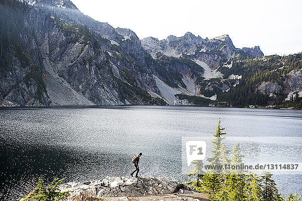 Side view of hiker walking on rocks by Snow Lake