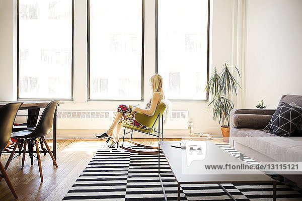 Businesswoman sitting on armchair in creative office