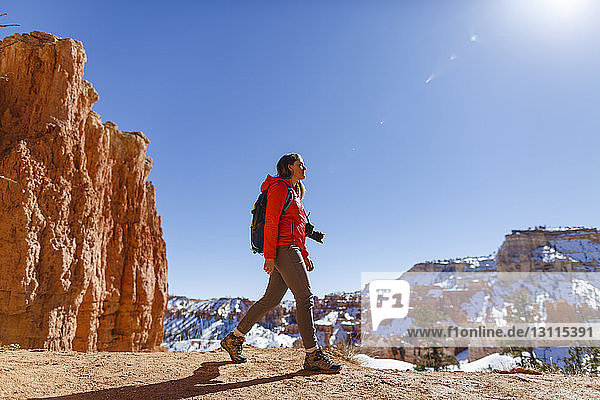 Wanderer wandert im Winter im Bryce Canyon National Park auf dem Berg gegen den klaren Himmel