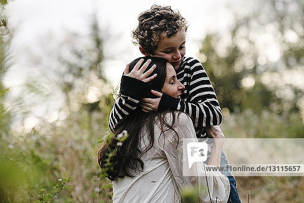 Liebender Sohn umarmt Mutter im Park