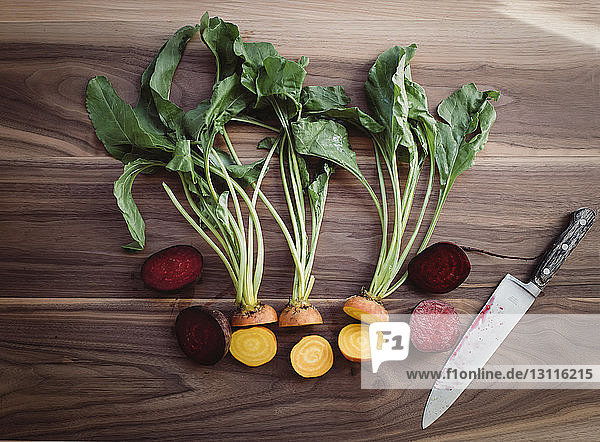 Draufsicht auf gehacktes Gemüse mit Küchenmesser auf Holztisch