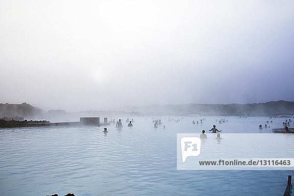 People swimming in Blue lagoon against sky