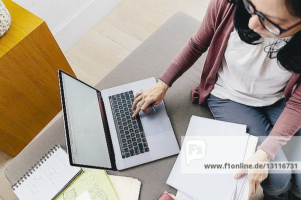 Schrägansicht einer Geschäftsfrau mit Laptop im Büro