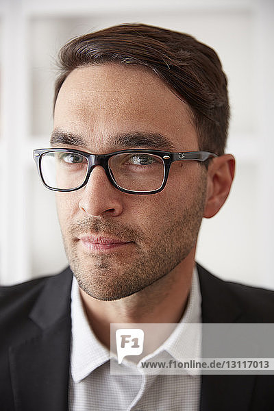 Close-up portrait of confident businessman at home
