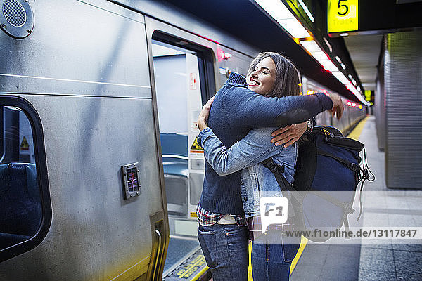 Liebespaar umarmt sich  während es mit dem Zug in der U-Bahn-Station steht
