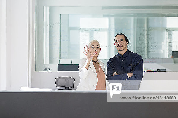 Kollegen  die im Büro arbeiten  durch Glas gesehen