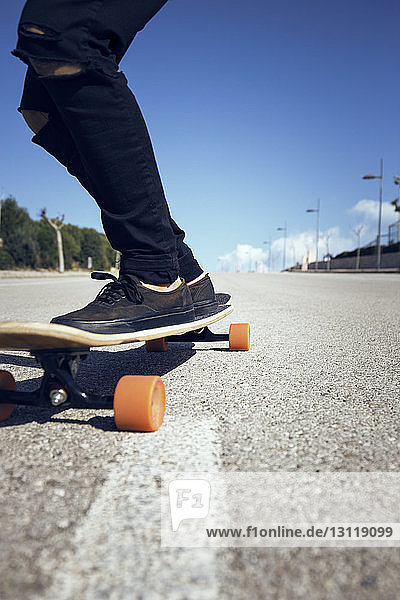 Niedriger Abschnitt eines Mannes beim Skateboarden auf der Straße