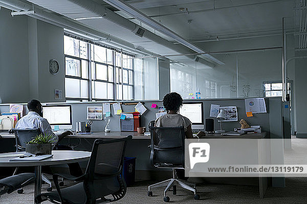 Rückansicht von Geschäftsleuten  die Desktop-Computer am Schreibtisch im Büro benutzen