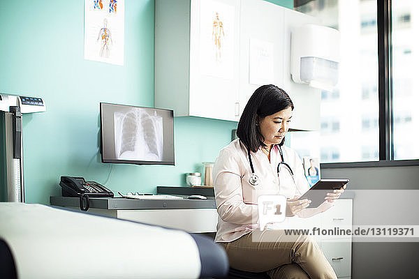 Female doctor using tablet computer in clinic