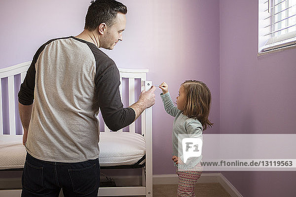 Vater und Tochter machen zu Hause ein Kinderbett