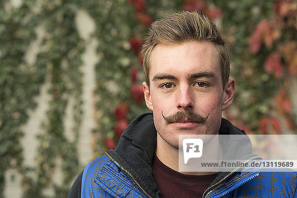 Porträt eines selbstbewussten Mannes mit Schnurrbart im Hinterhof
