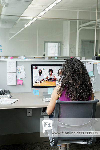 Geschäftsfrau Videokonferenz mit Kollegen über Desktop-Computer am Schreibtisch im Büro
