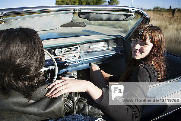 Porträt einer Frau  die mit einem Mann in einem Cabriolet sitzt