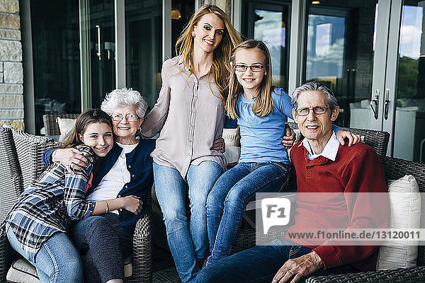 Porträt einer glücklichen Familie auf der Veranda sitzend