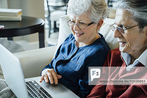 Senior couple using laptop computer in living room