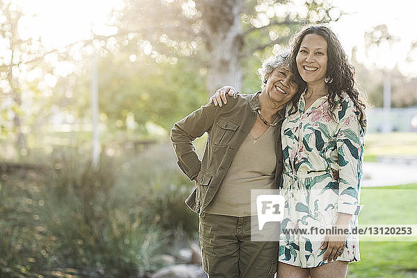 Porträt einer glücklichen Mutter und Tochter im Park stehend