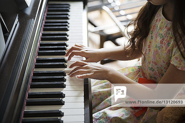 Hochwinkelaufnahme eines zu Hause Klavier spielenden Mädchens