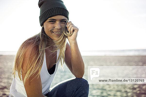 Portrait of happy woman sitting on beach