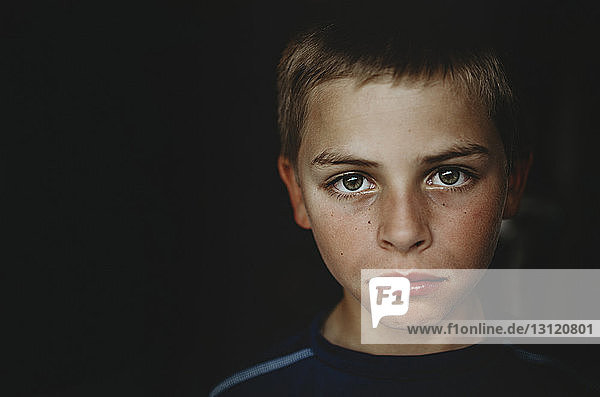 Porträt eines Jungen in dunkler Kammer