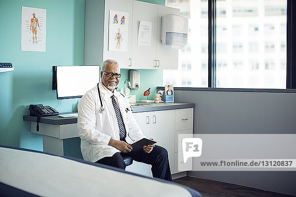 Porträt eines selbstbewussten Arztes mit Tablet-Computer in der Klinik
