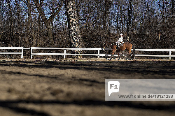 Seitenansicht des Reitens von Mädchen auf der Ranch