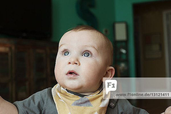 Close-up of cute baby looking away at home