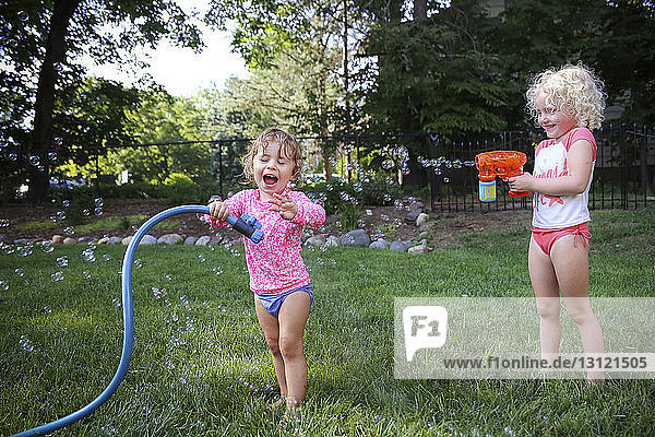 Happy sisters playing in backyard