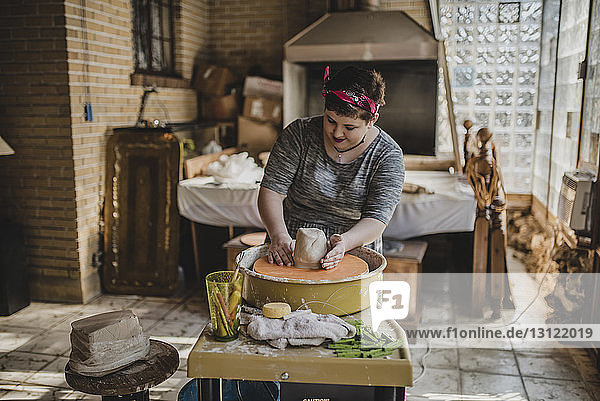 Female potter making clay pot at pottery