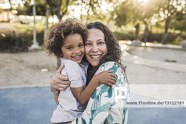 Porträt einer glücklichen Mutter und ihres Sohnes bei der Umarmung im Park
