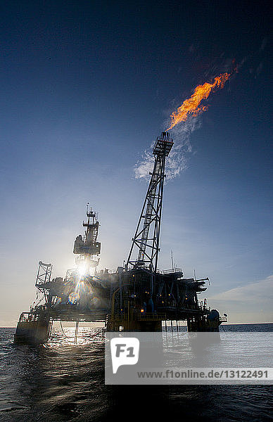 Ölplattform im Meer  die an einem sonnigen Tag Feuer ausstößt